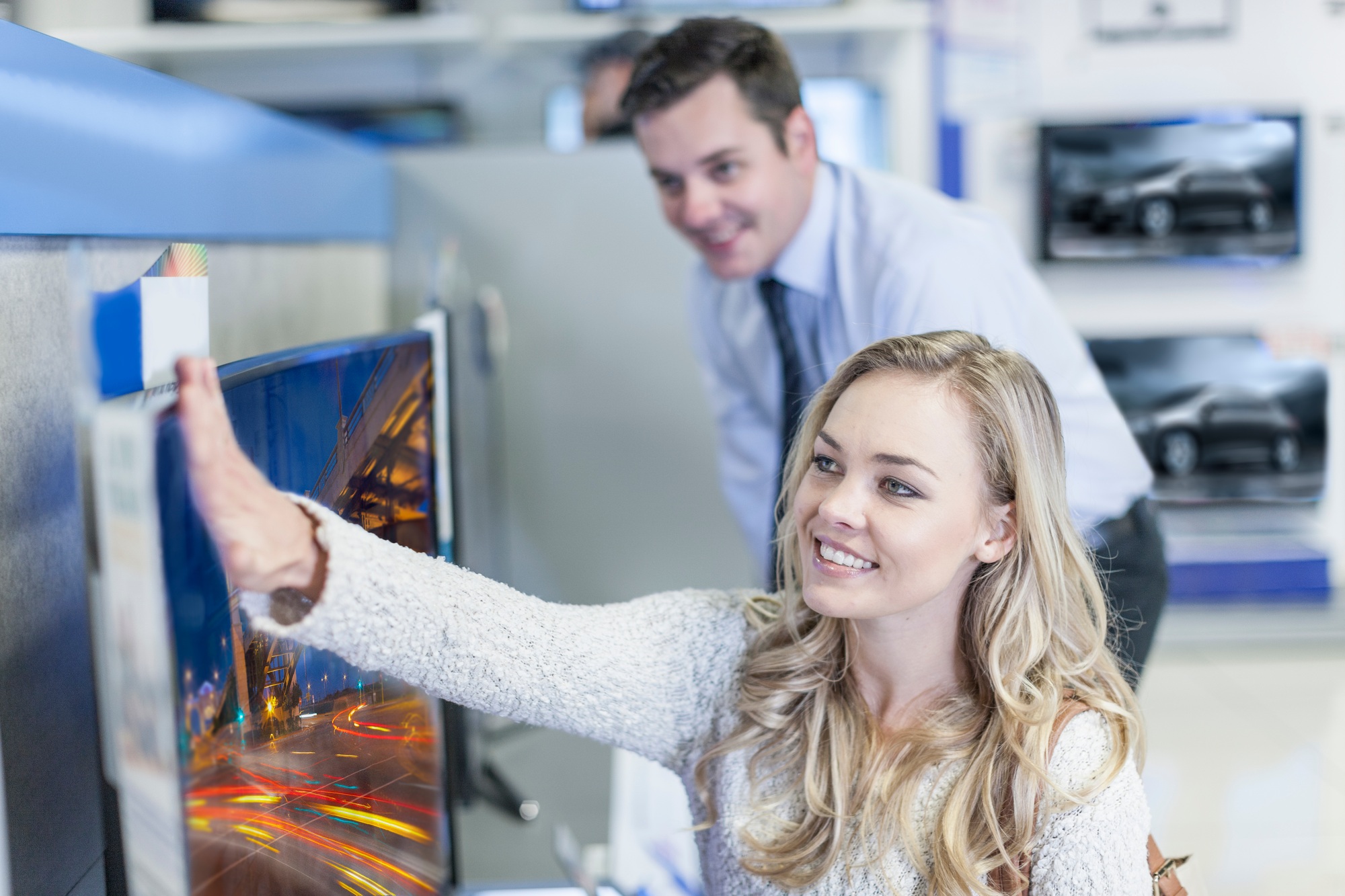 Customer examining flatscreen TV in shop